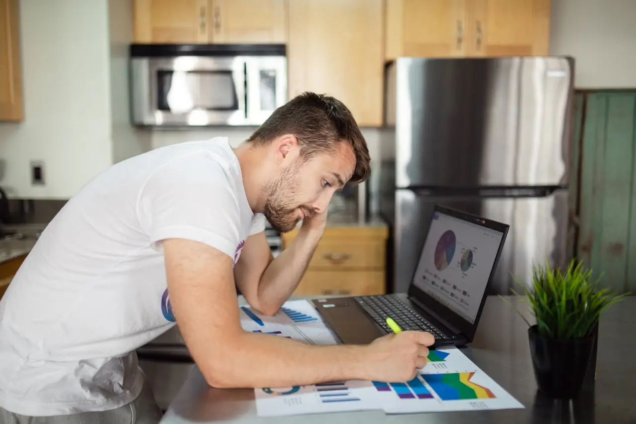 retail sales representative job-man-in-white-t-shirt-using-laptop-computer