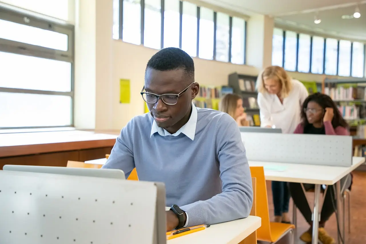 GREAT Scholarships smart-young-ethnic-guy-browsing-laptop-during-lesson-in-university-