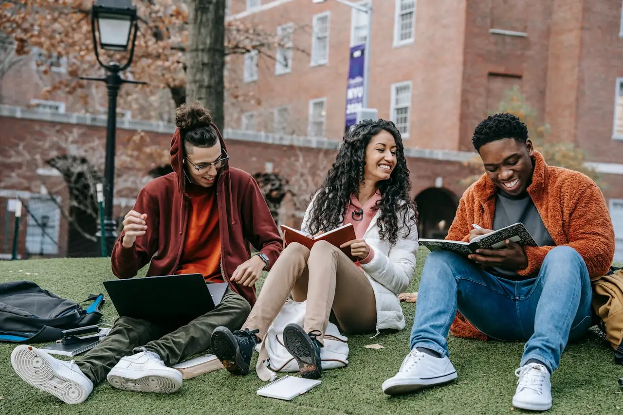 International Leadership cheerful-multiethnic-students-with-books-sitting-near-university