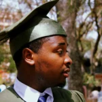 close-up-photo-of-a-global academic excellence scholarship man-wearing-green-academic-dress