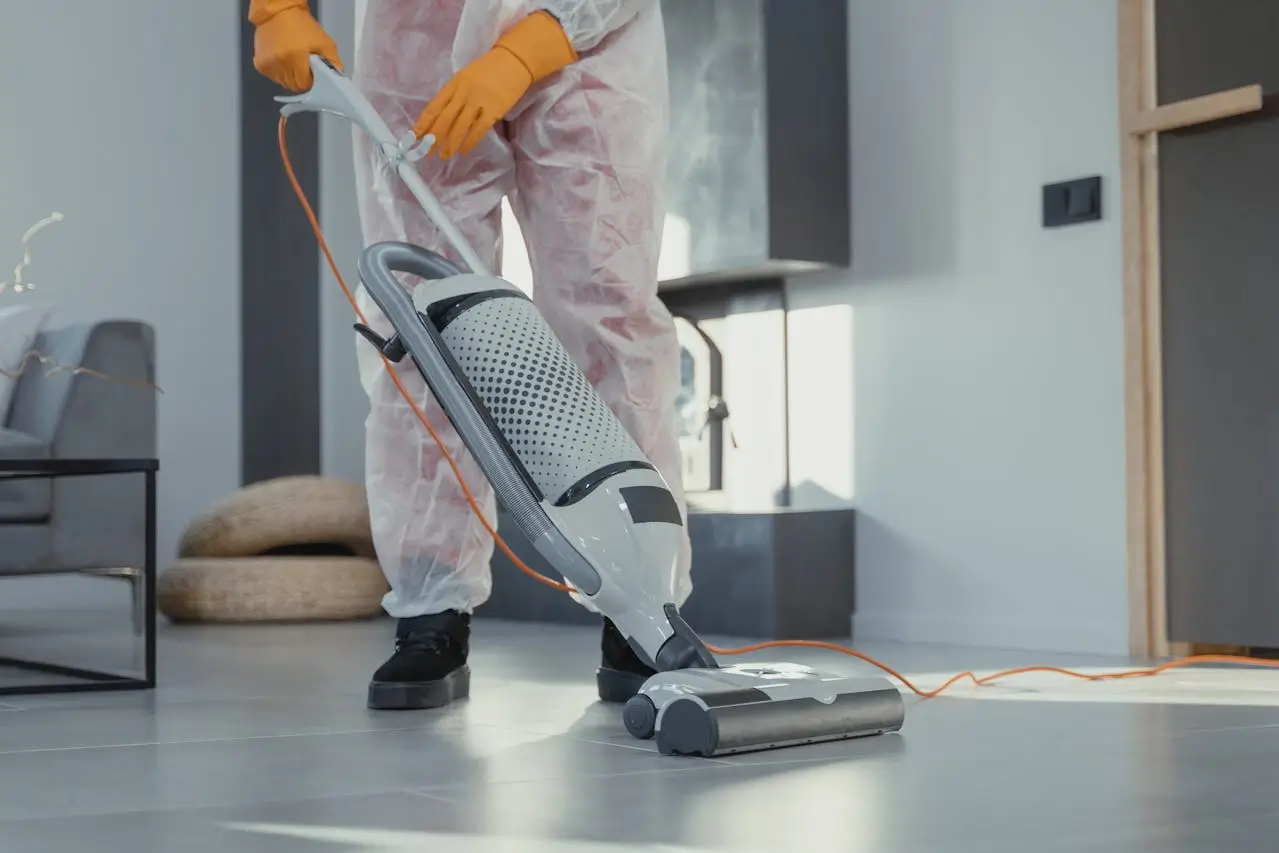 a housekeeper/cleaners job man-using-a-vacuum-on-floor-tiles