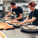 restaurant supervisor job man-and-woman-wearing-black-and-white-striped-aprons-cooking