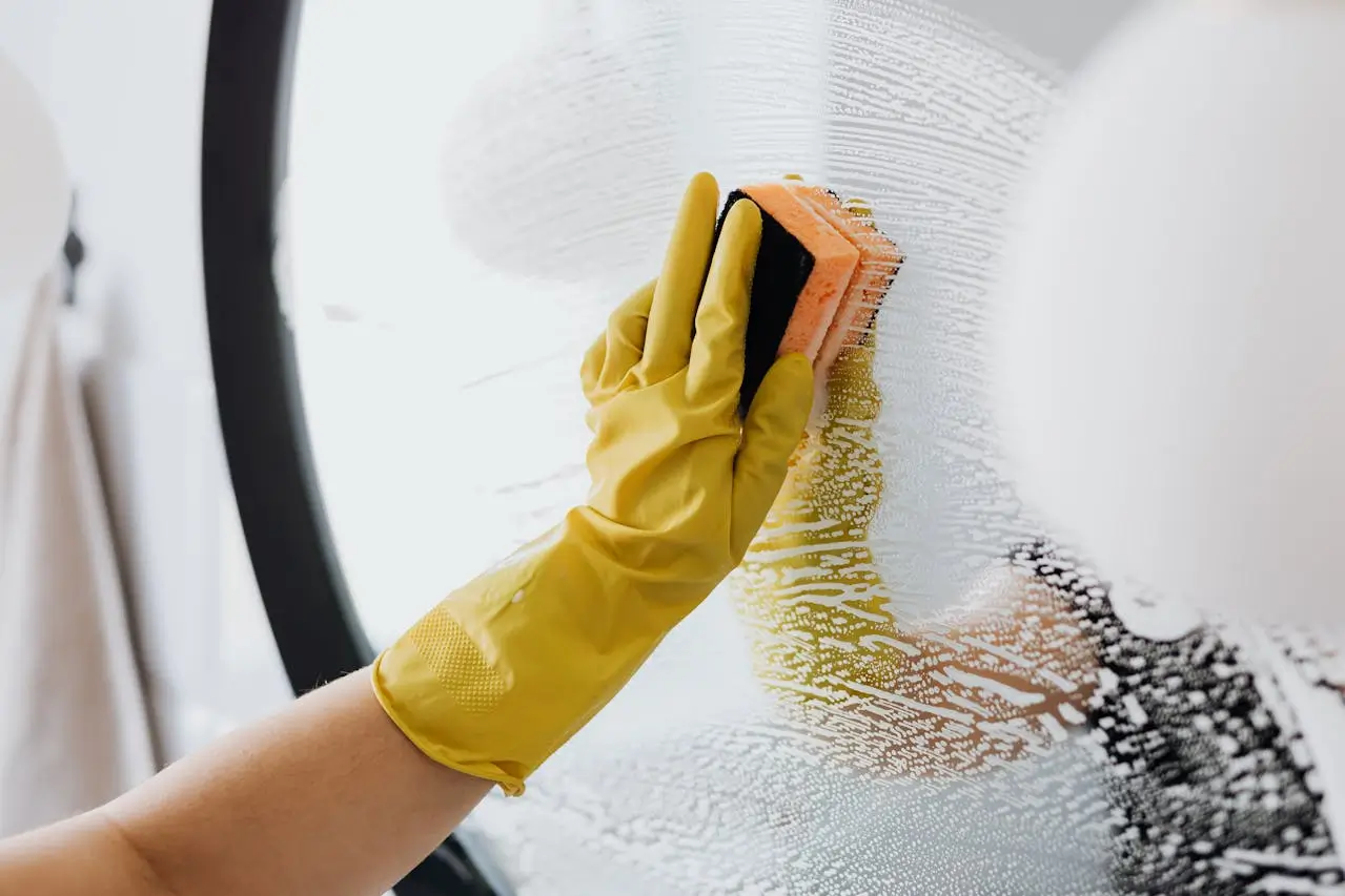 faceless housekeeper cleaning the glass