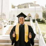 president's PhD scholarships man-wearing-graduation-gown-posing